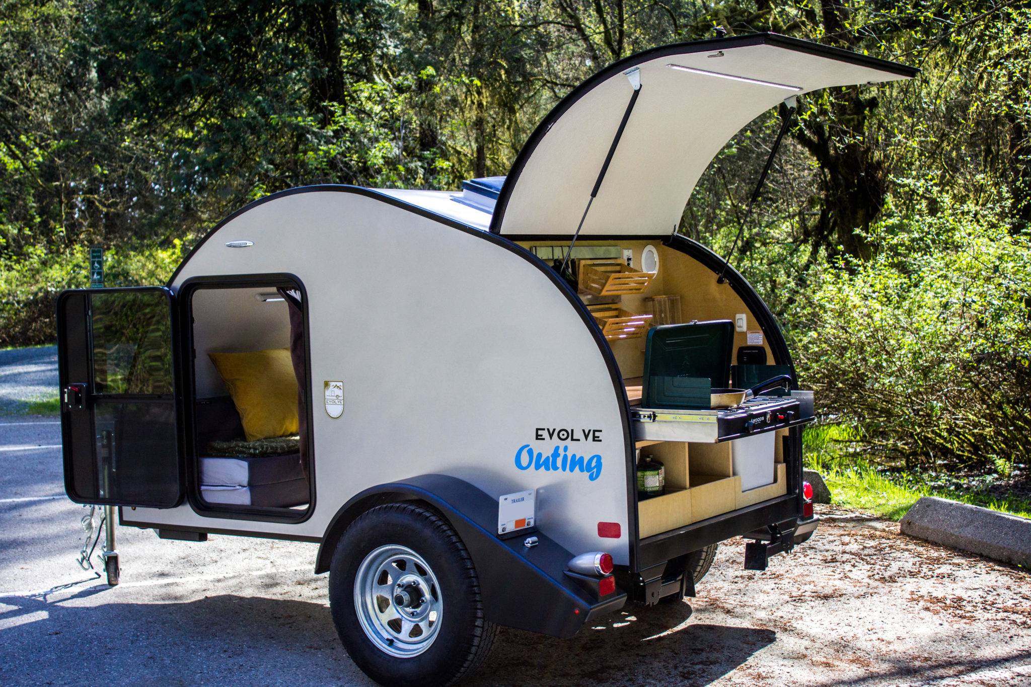 The Evolve Outing Teardrop Trailer set-up at camp site with side door and kitchen open