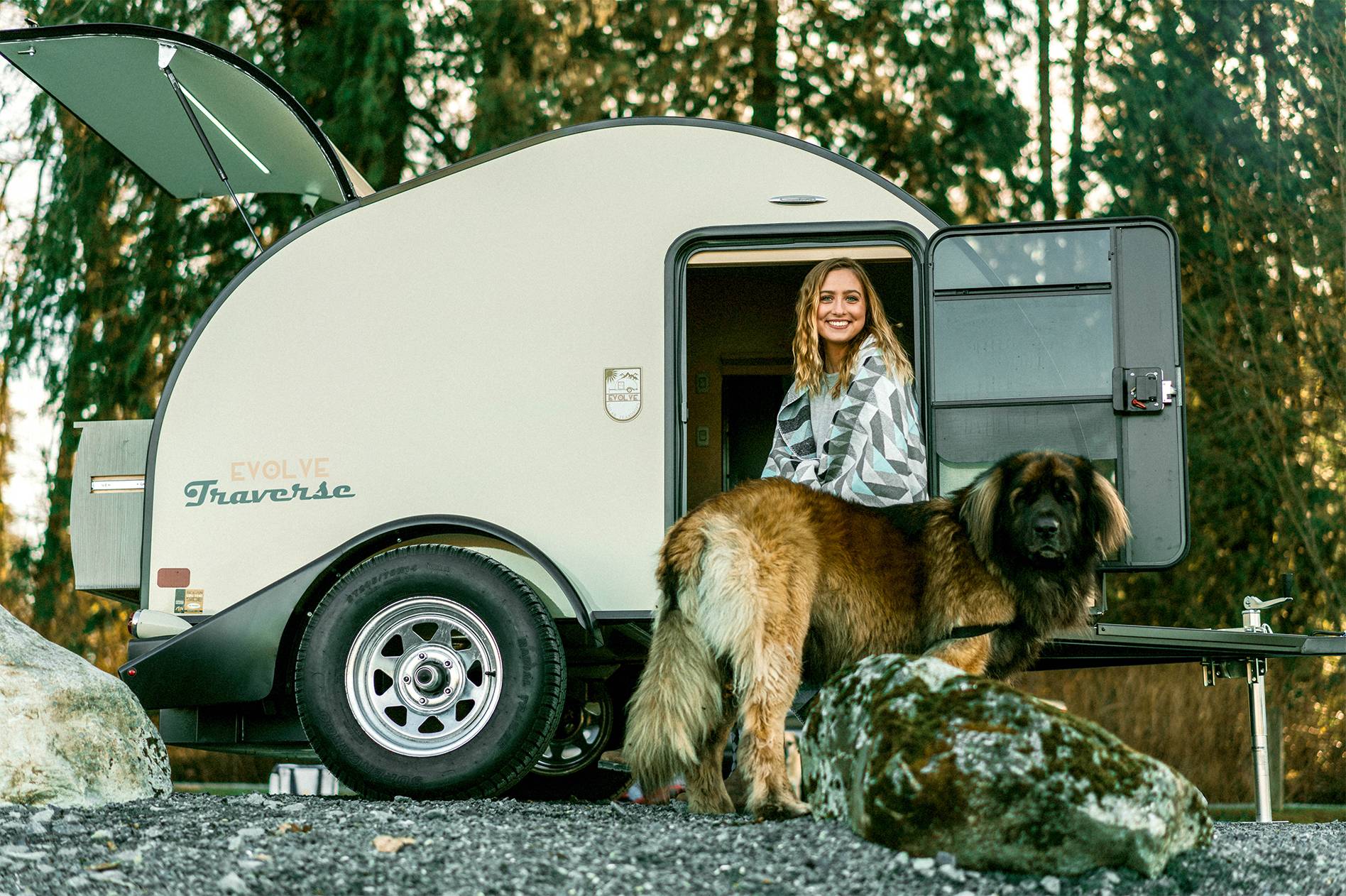 Girl with dog sitting in the Evolve Traverse Lightweight Solar Teardrop Trailer