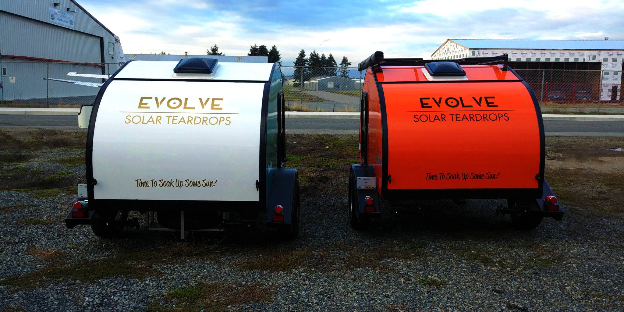 White and red Evolve Solar Teardrop Trailers side by side
